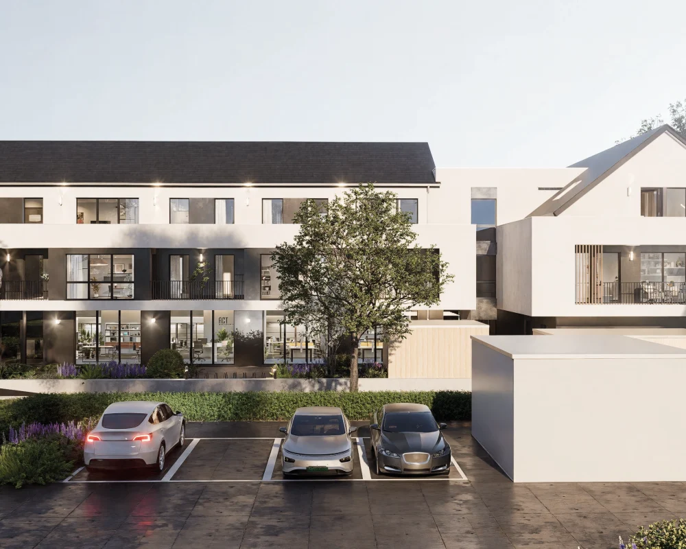 Modernes, dreistöckiges Gebäude mit geparkten Autos und einem großen Baum im Vordergrund. Eine Person steht auf einem Balkon.